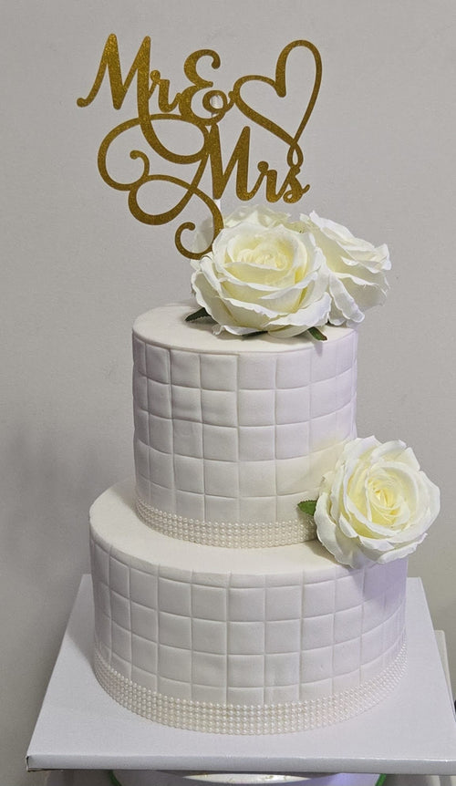 2-tier white quilted fondant wedding cake with white roses and gold Mr and Mrs topper